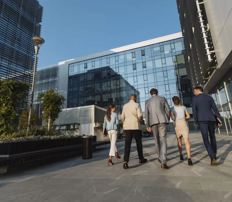 Haciendo negocios en BC - Gente de negocios caminando al aire libre.