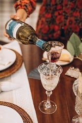 A close-up of wine being poured into an empty glass.