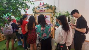 Several people standing in a line waiting to taste blueberries and cherries inside the pop-up show.