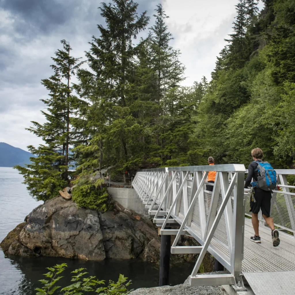 People crossing bridge while hiking along the coast in Prince Rupert.
