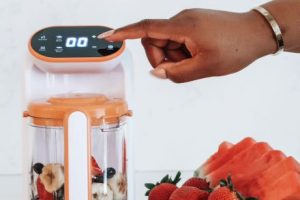 Woman's hand presses button on a food processor. 