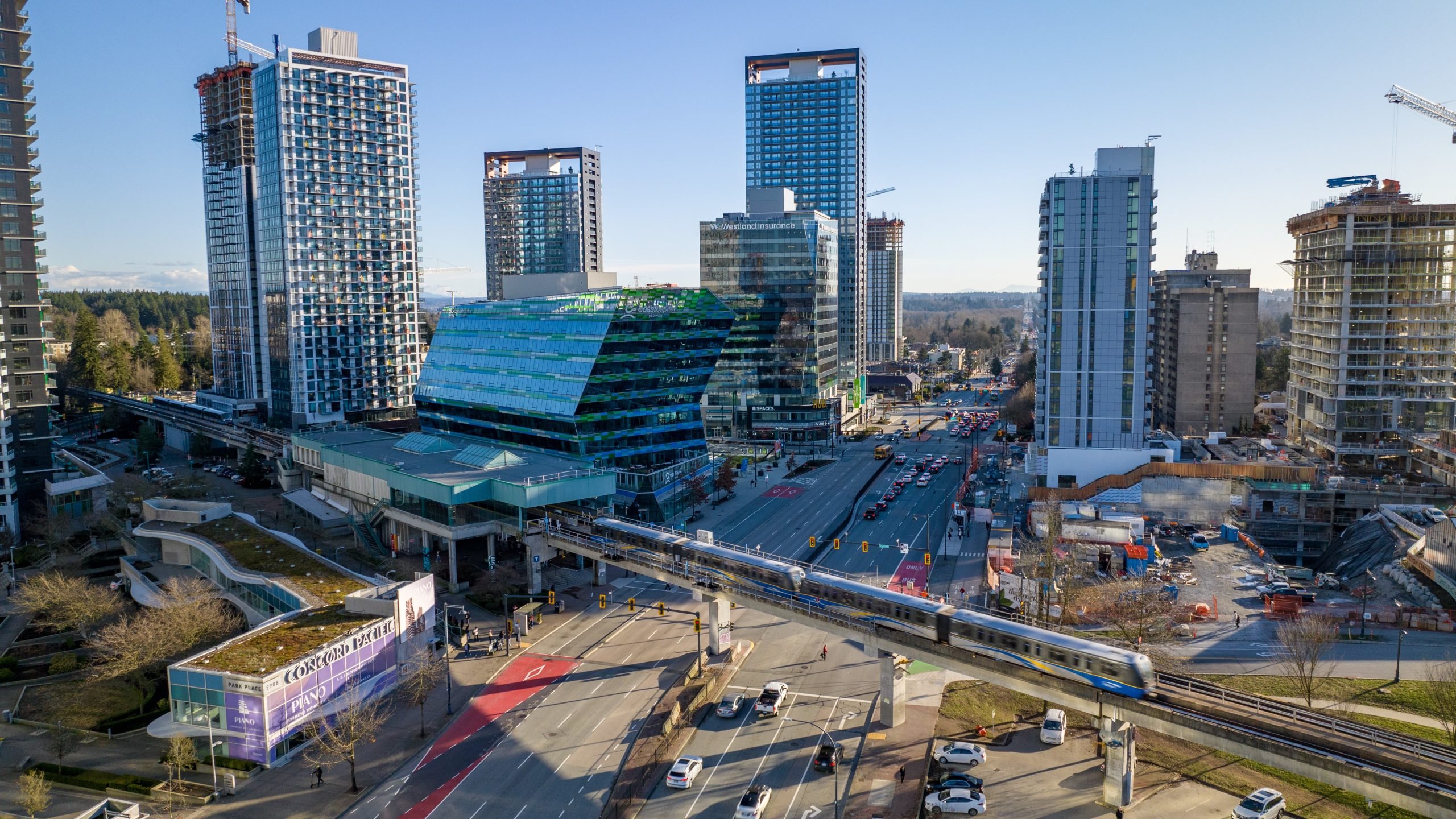 Drone shot of several skyscrapers and the sky train in downtown Surrey. 
