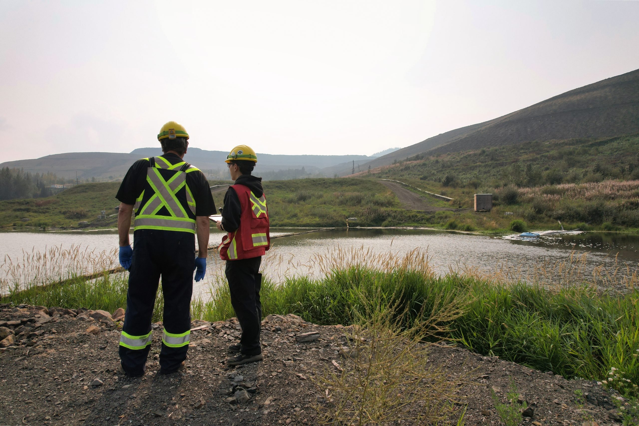 Employees completing an inspection of a sedimentation pond in Tumbler Ridge