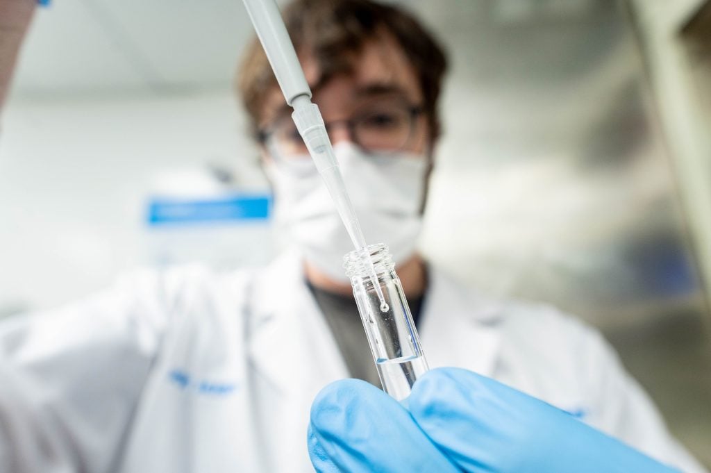 A technician handles a sample within a radiopharmaceutical processing laboratory at TRIUMF