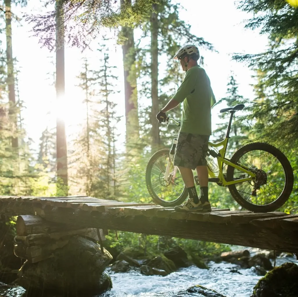 Un vététiste traversant un rondin à Whistler