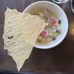 A bowl of ceviche with diced fish, radish, herbs, and beans, highlighting British Columbia’s seafood sector and agri-food diversity; large crisp cracker beside.