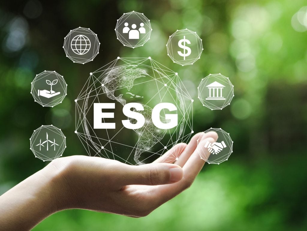 ESG icon concept in the hand for environmental, social, and governance in sustainable and ethical business on the Network connection on a green background.