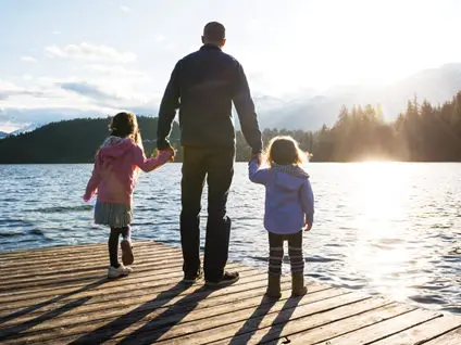 Father holding two daughters' hands